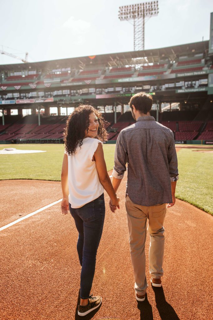 Couple walks the field at Fenway Park during their Boston engagement photos
