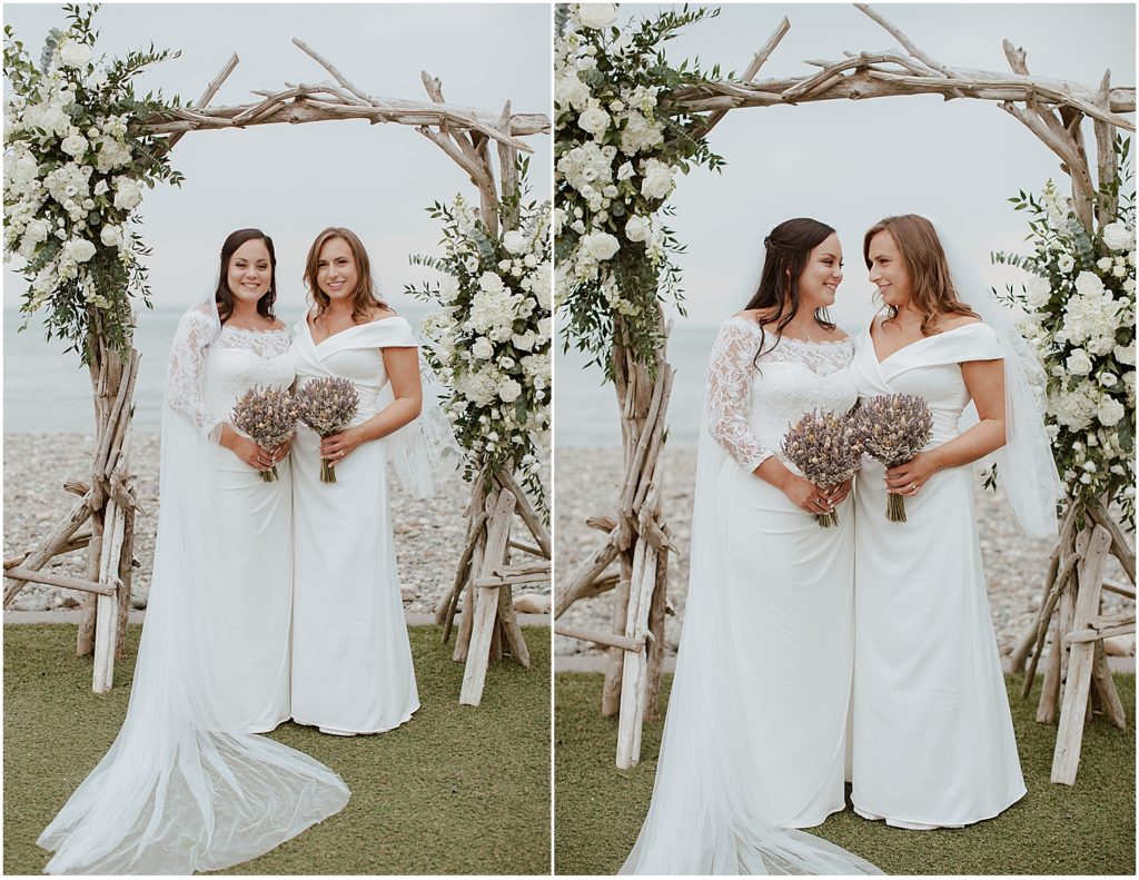 Brides-posing-under-driftwood-ceremony-arch-in-Nahant